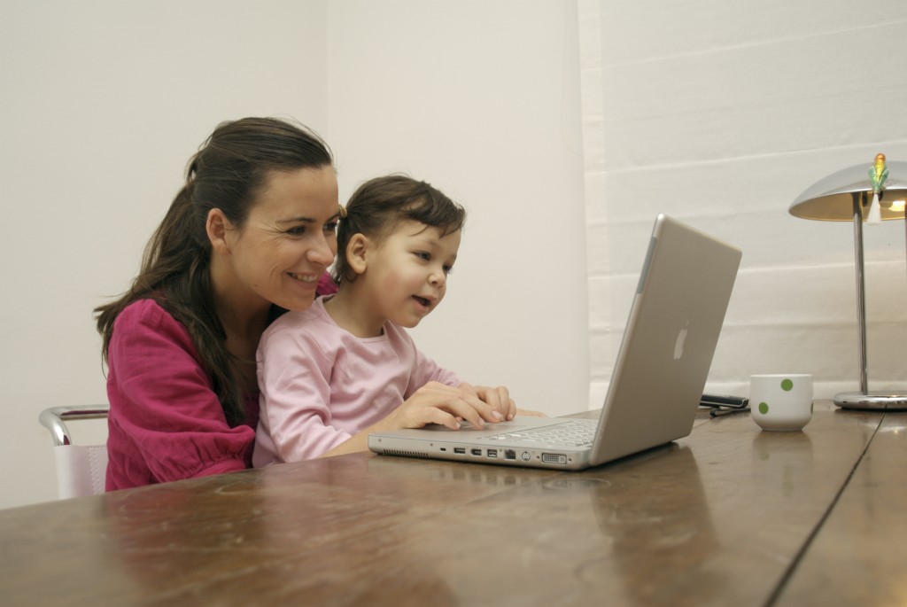 Mutter mit Kind vor dem Laptop